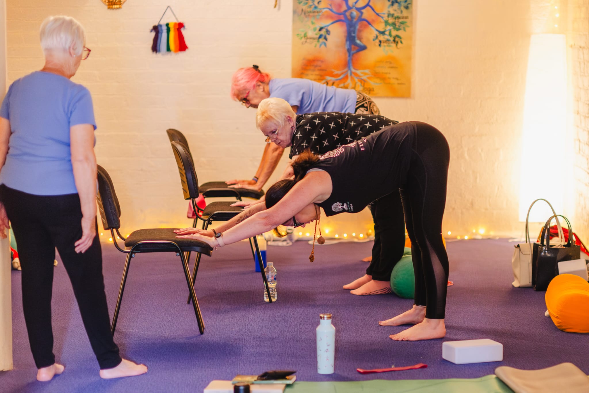 Students using chairs for support during a Dru Yoga class